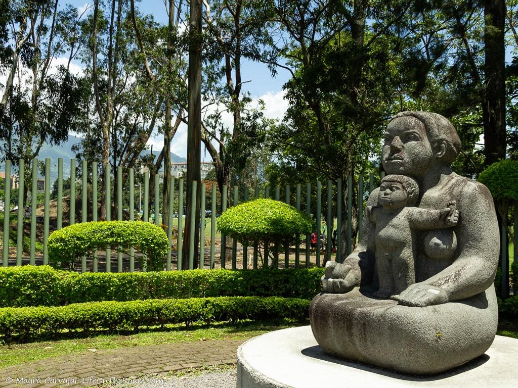 A sculpture of mother and child in a garden
