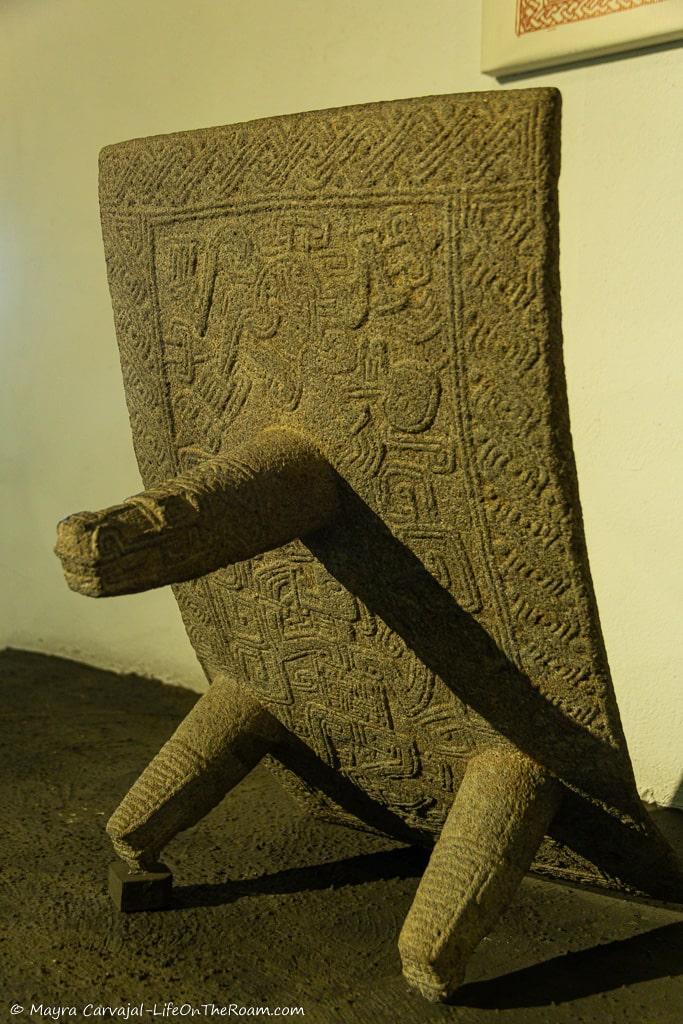 A carved stone convex surface on three legs