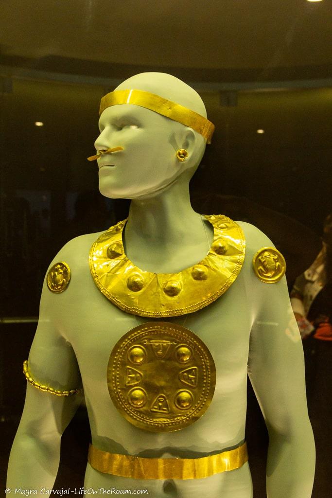 A mannequin with gold accessories