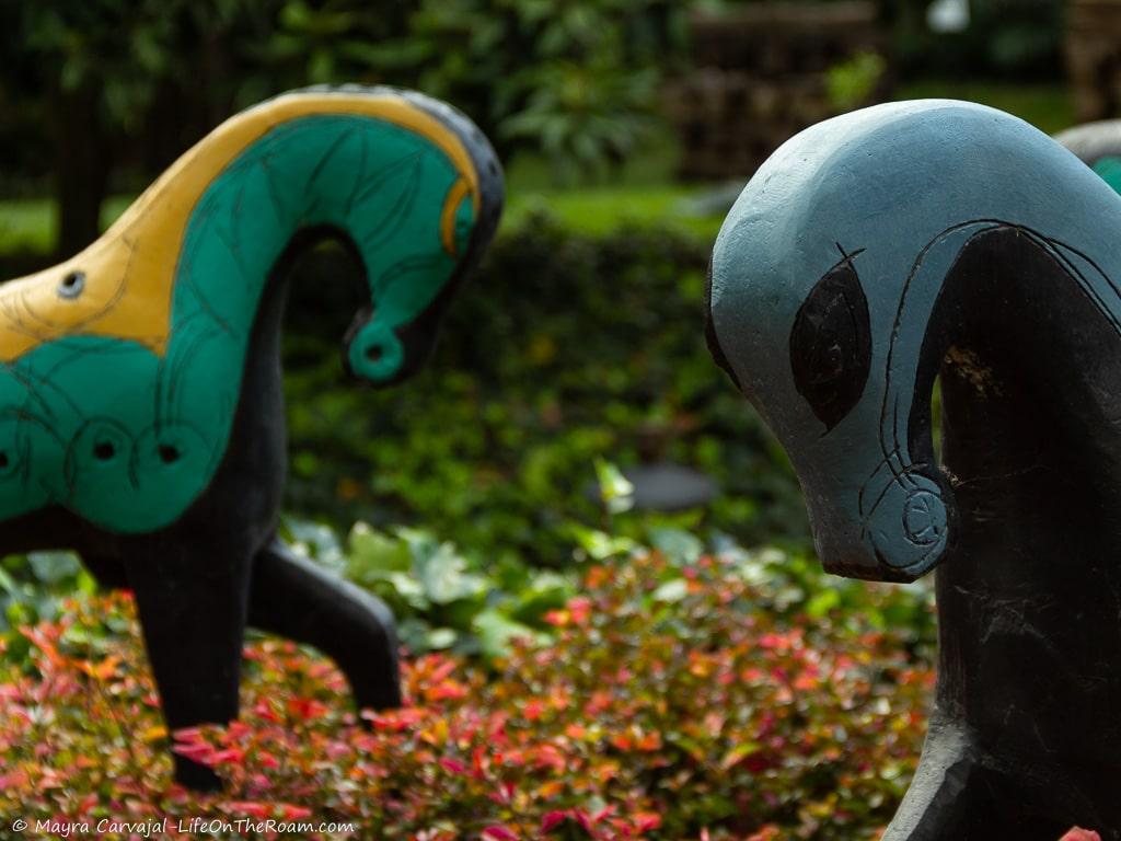 Sculptures of multicolour horses in a garden