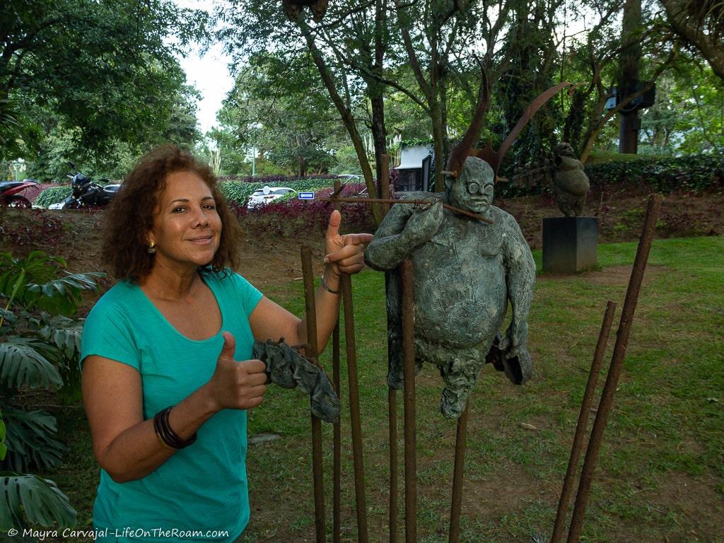 Woman standing next to an anthropomorphic statue on a rebar