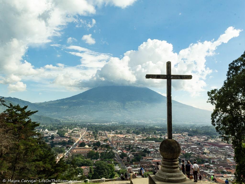 View of a volcano from a lookout, with a cross in the foreground