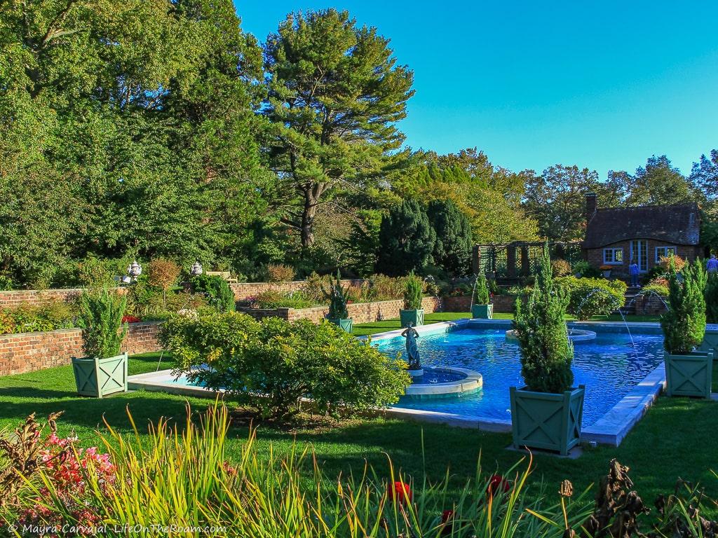 A garden with a rectangular pool and sculptures