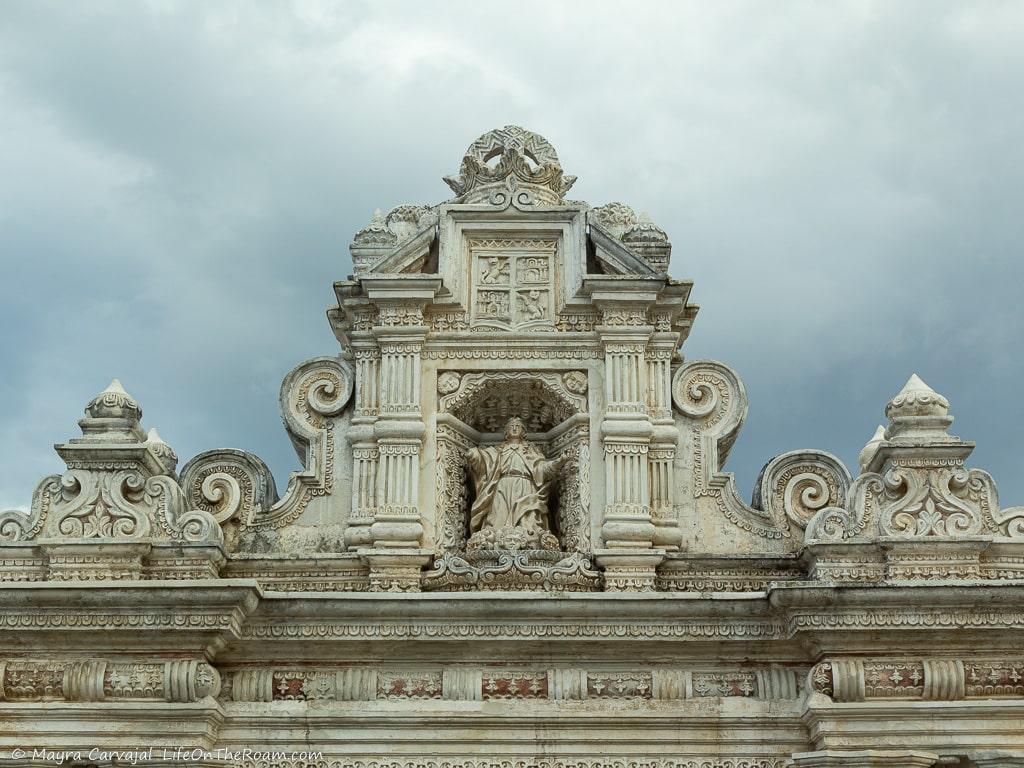 Intricate decoration on the top section of a white building 