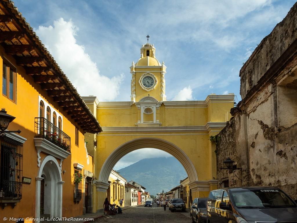 An arch painted in yellow connecting two streets