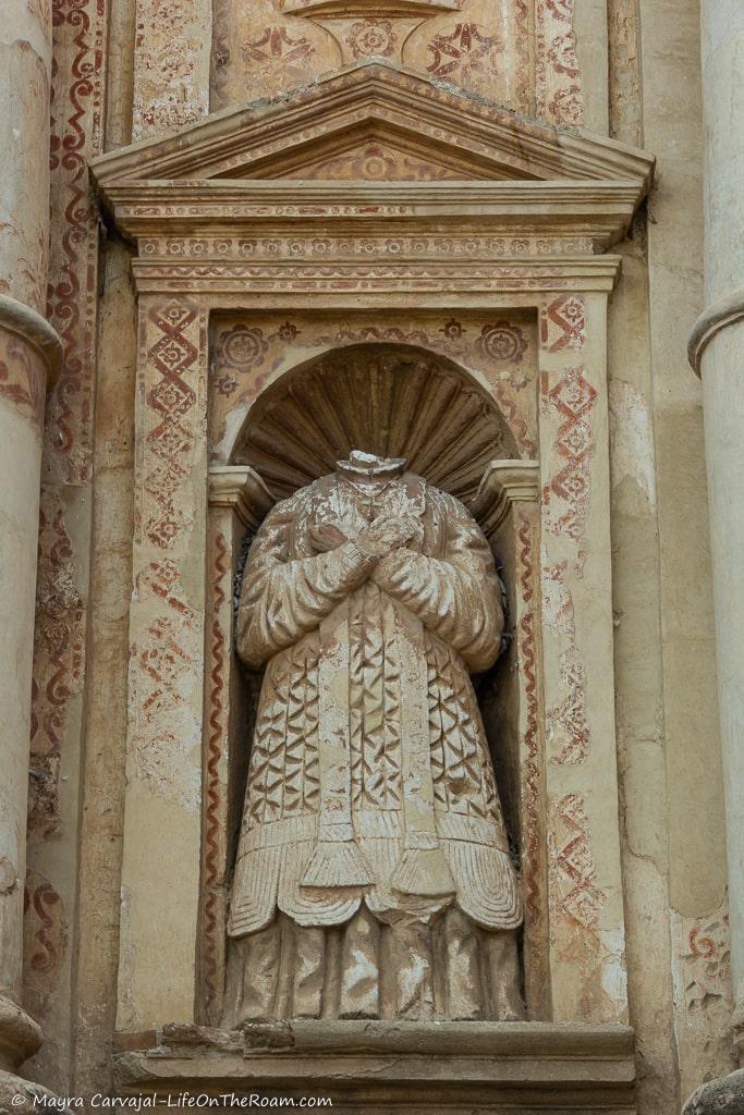 A headless statue in a niche