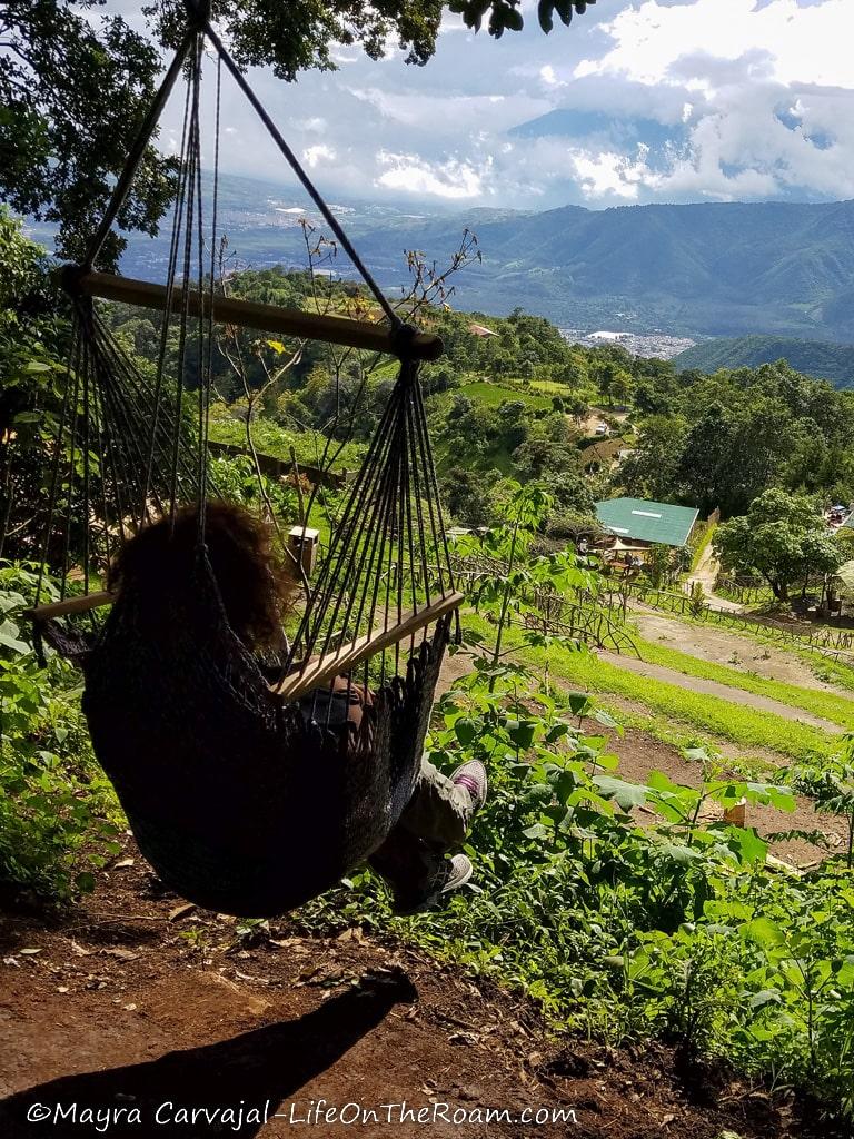 A woman on a swing looking at the mountains