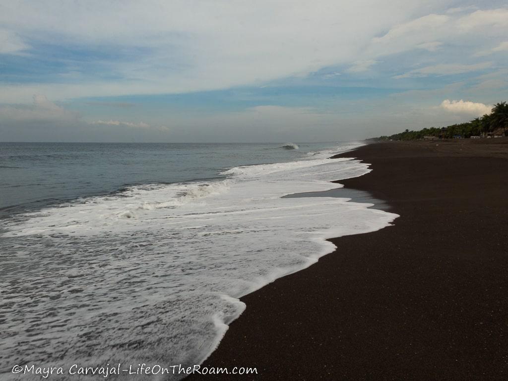 A beach with dark sand