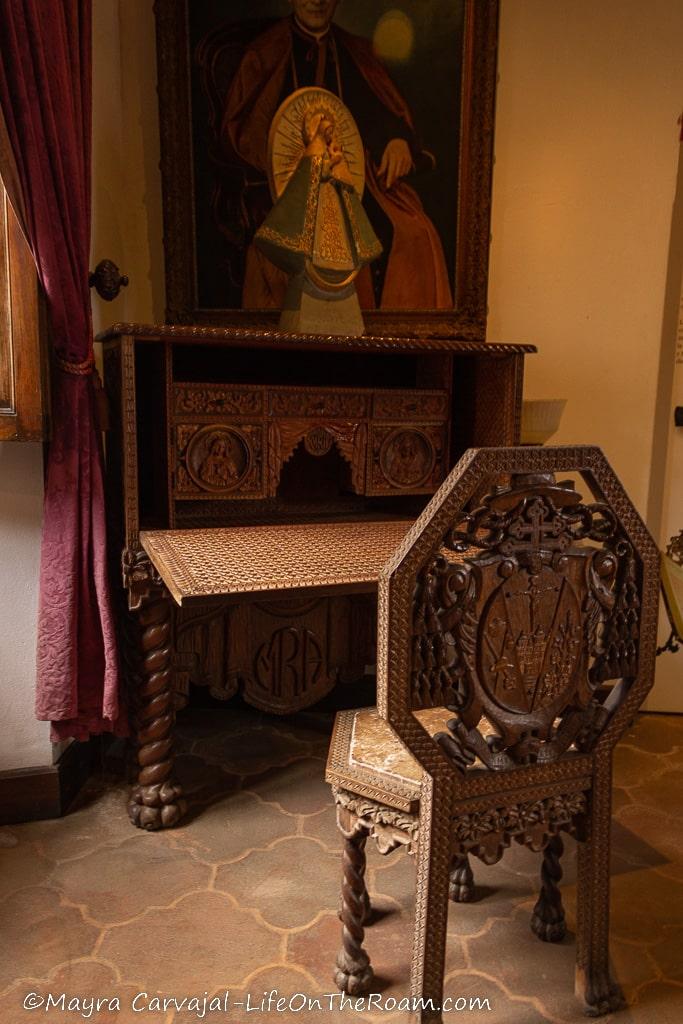 A wood desk and chair with intricate carving
