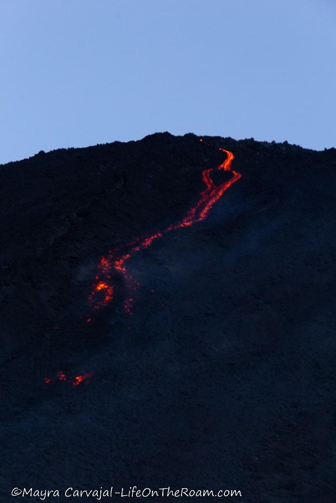 Flaming lava descending from a volcano crater