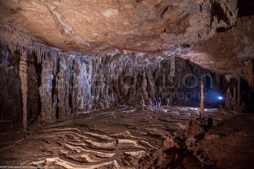 A group of people inside a cave with tall ceilings
