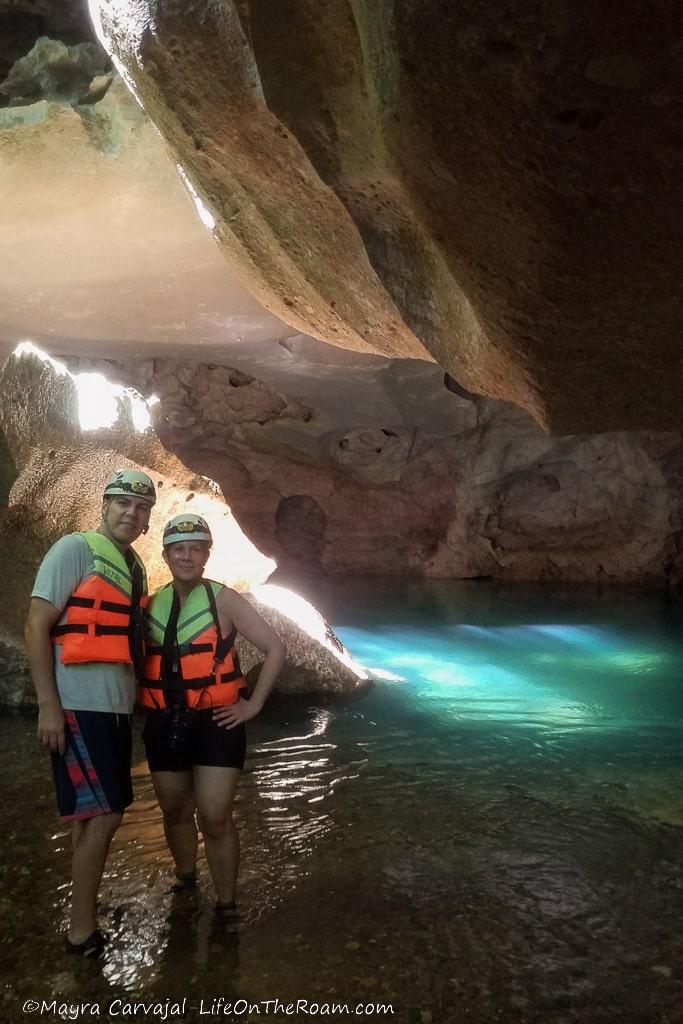 A couple standing inside a cave with water