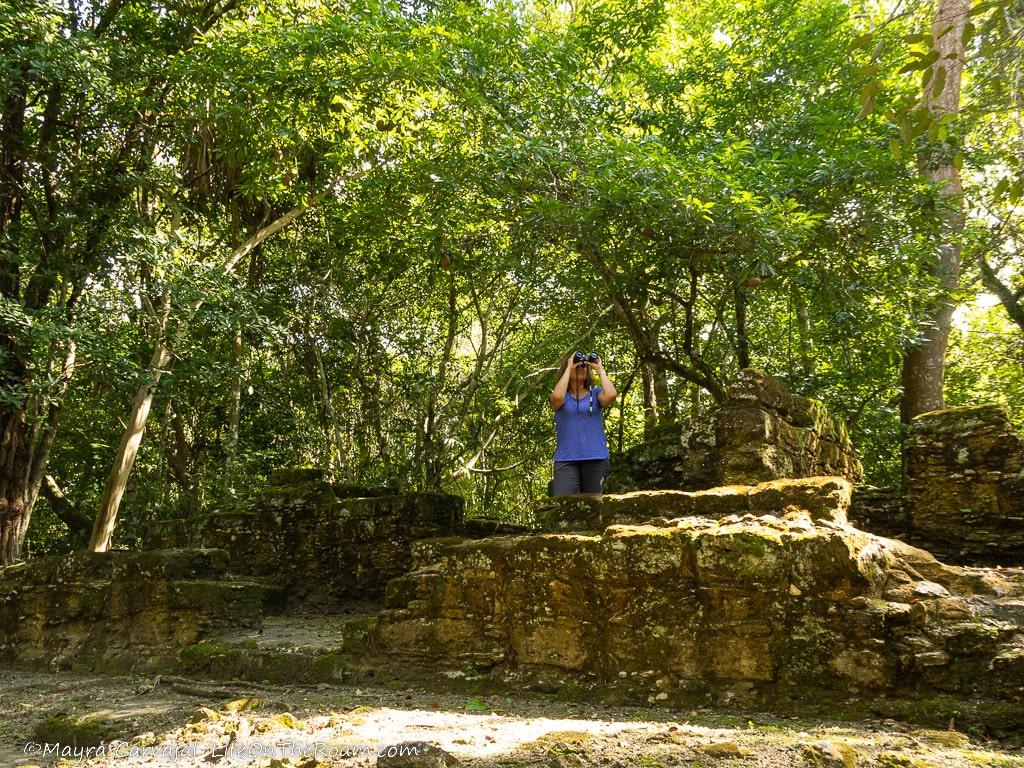A woman standing in the centre of the ruins of an ancient house