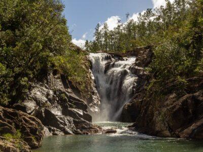 A tall waterfall pouring over rocks in a forest