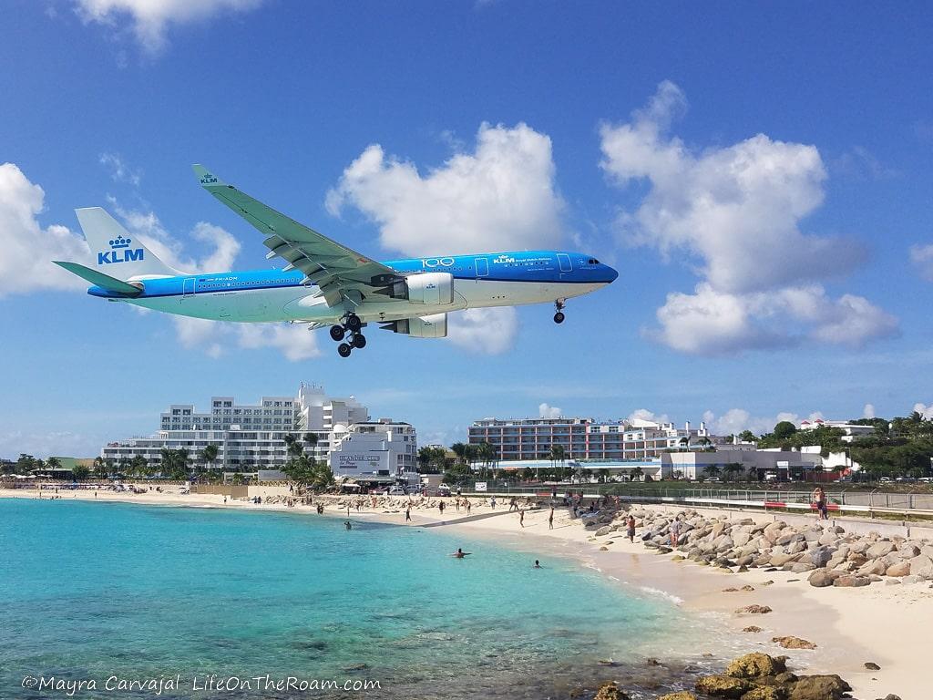 A big plane flying low over a beach before landing