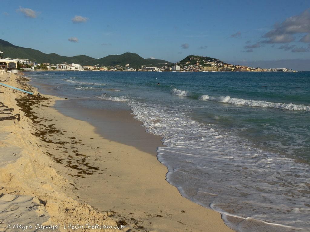 A sandy beach with mountains in the background