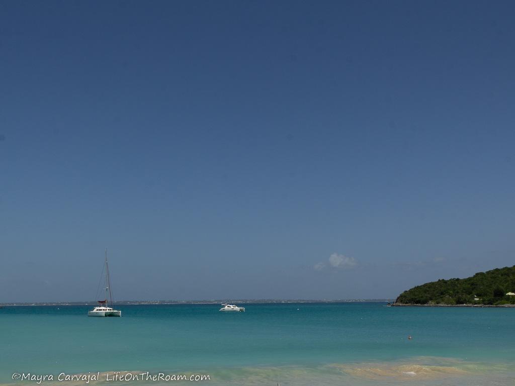 A bay with turquoise waters and boats in the distance