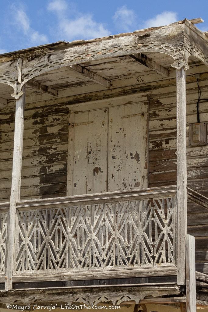 An intricate wood lattice on a porch of a house  with a door