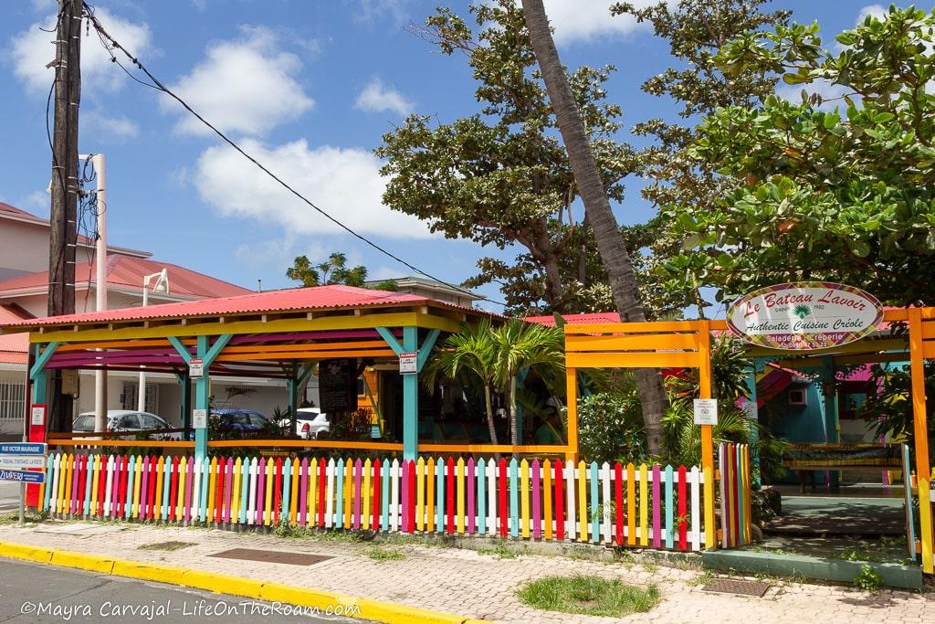 A restaurant in Caribbean traditional style with a colourful picket fence.