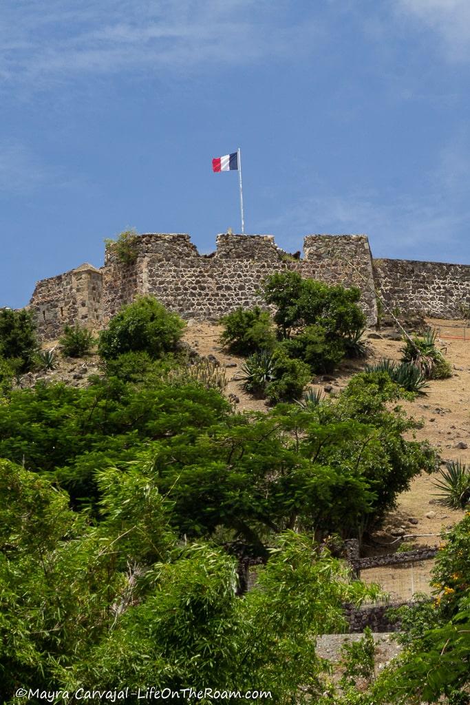 A historic fort with stone walls and the French flag on top