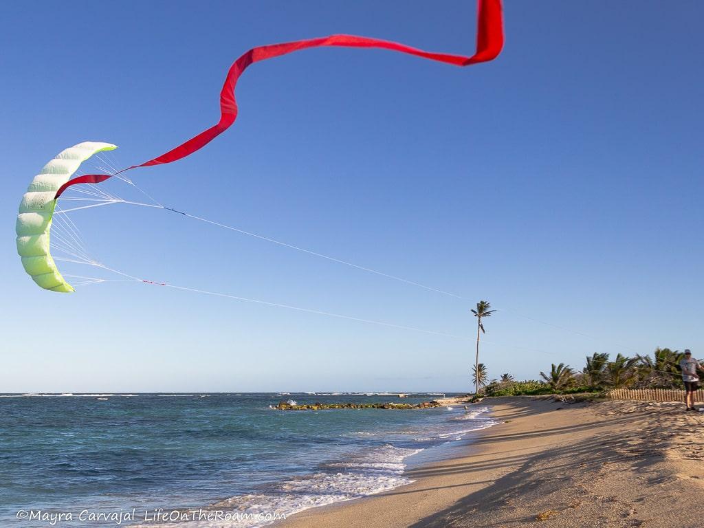 A man flying a kite on a sandy beach