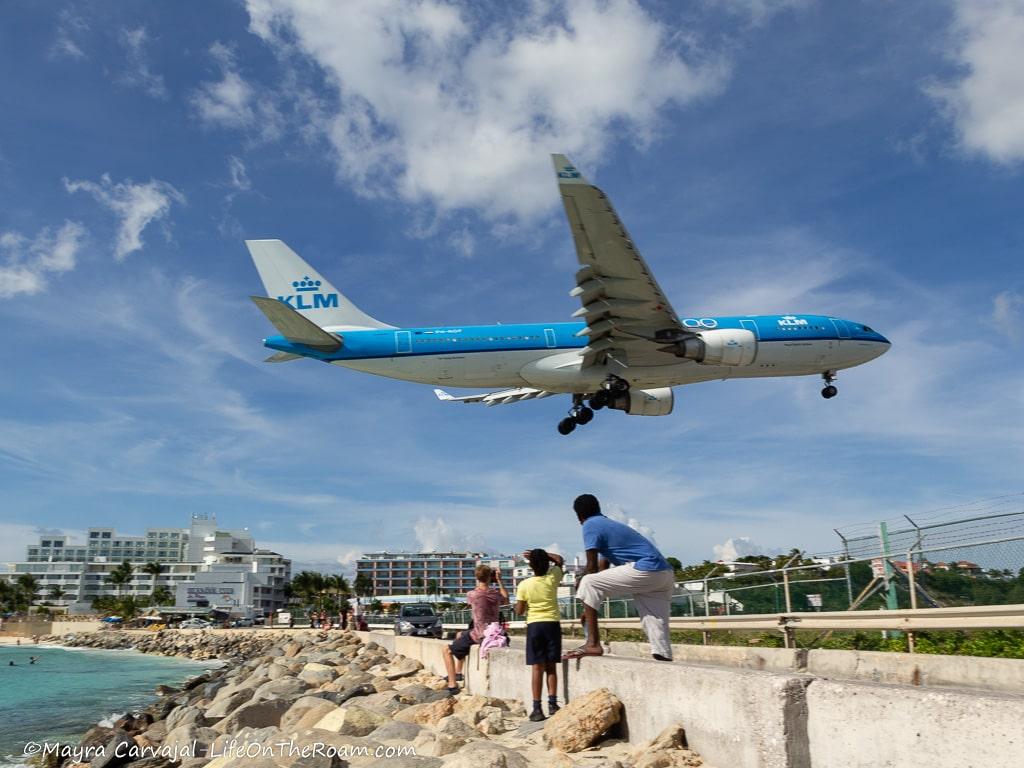 A large plane landing low next to the beach