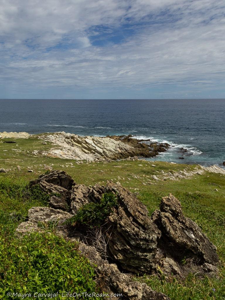 View of the sea from a coastal trail with grass and rocks