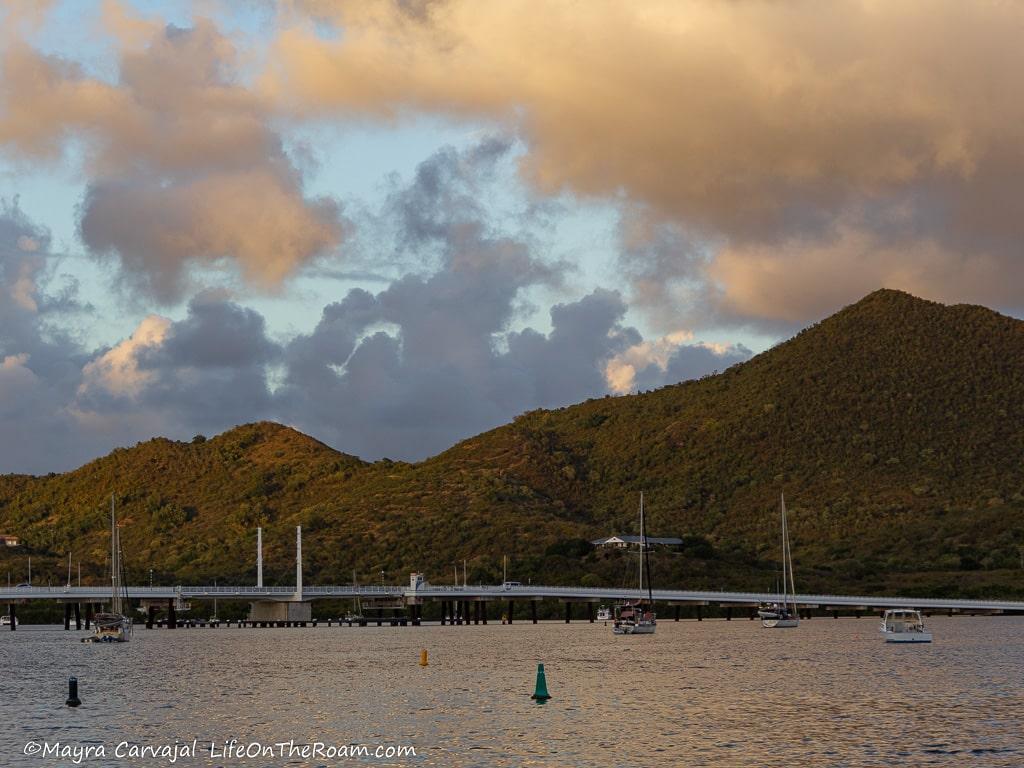 A white bridge in the distance over a lagoon with hills in the background