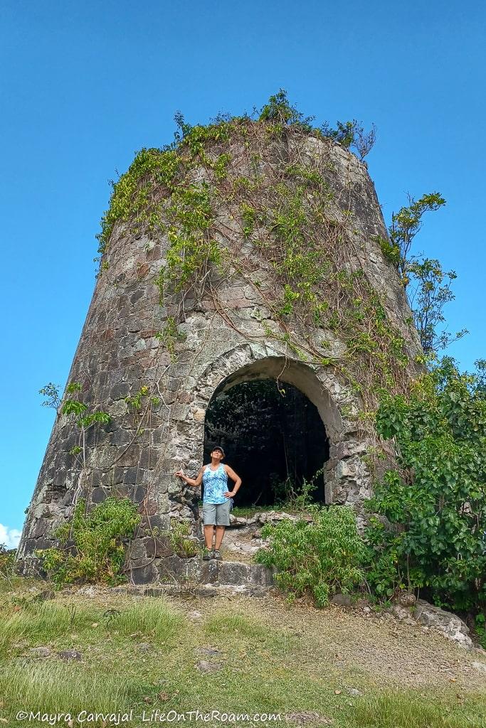 Mayra standing in front of the ruins of a sugar mill