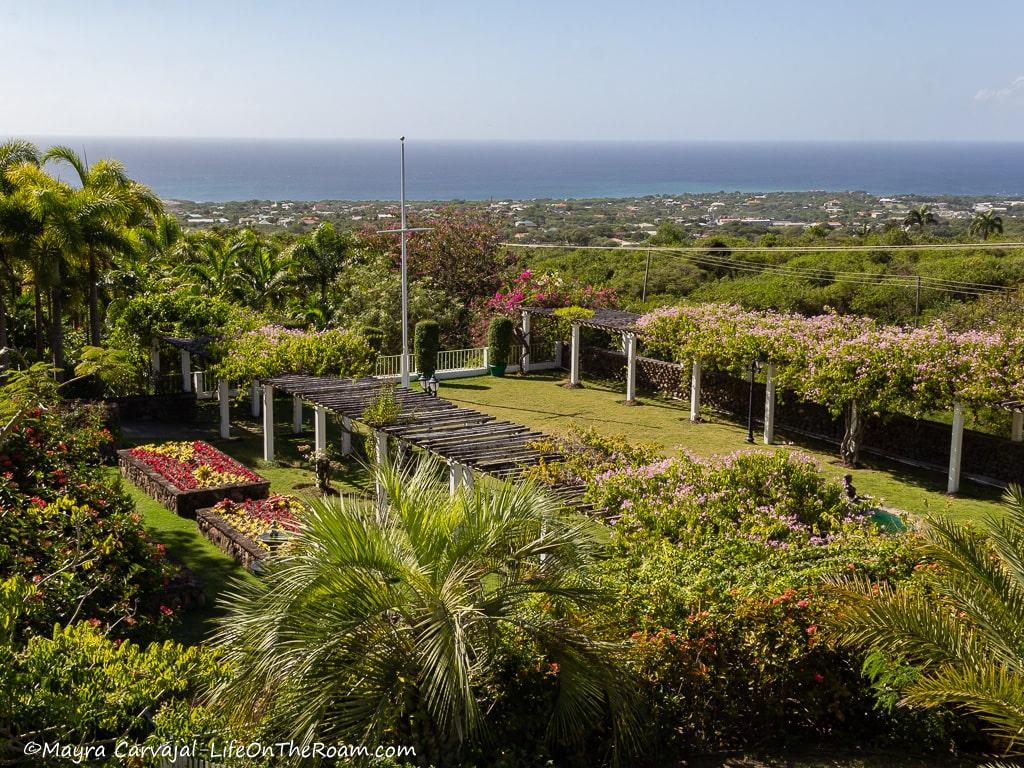 Aerial view of formal gardens and the sea in the distance.