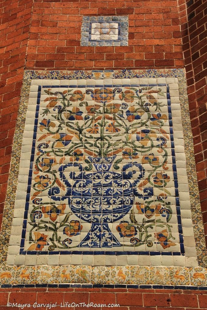 A tile panel with floral motifs surrounded by brick tiles