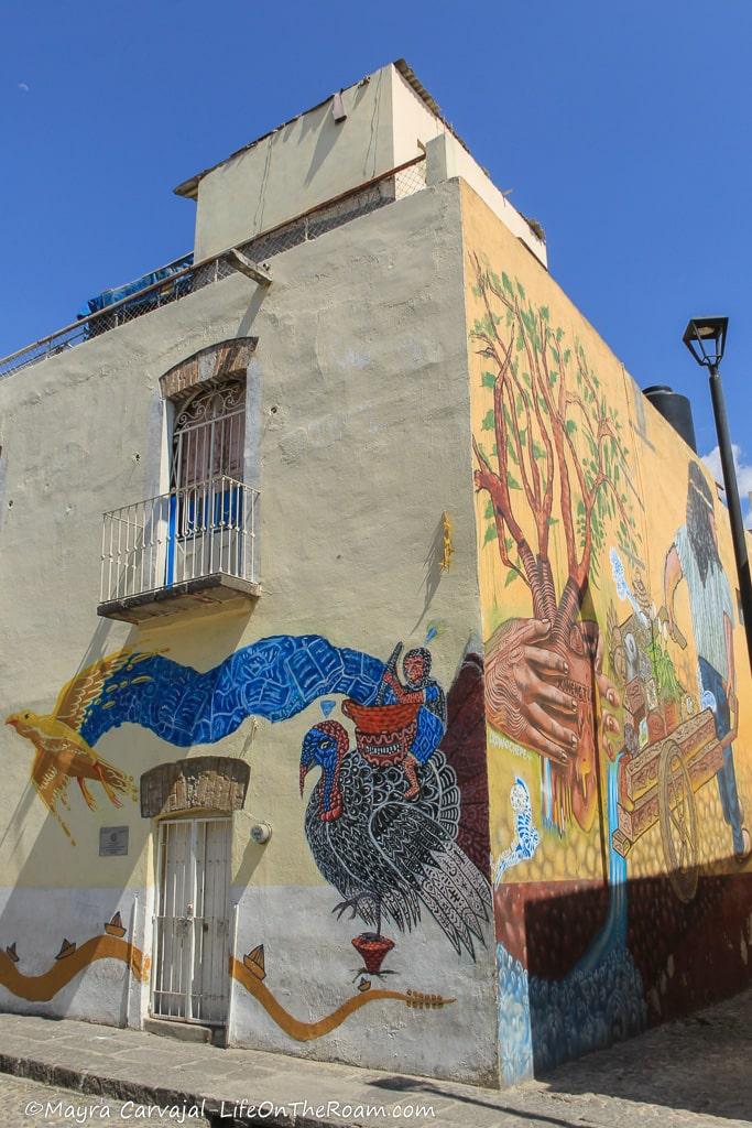 A mural at the corner of a building depicting a worker with a wheelbarrow on one side and a turkey on the other
