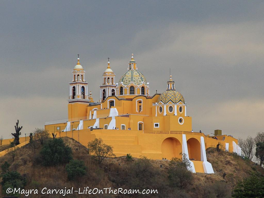 A yellow church at the top of a hill