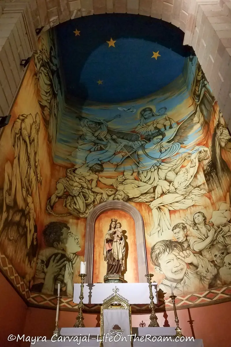 A mural on a church surrounding a niche