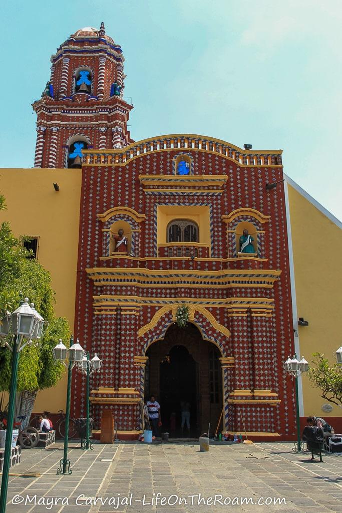 A church with brick and blue tiles and  yellow walls