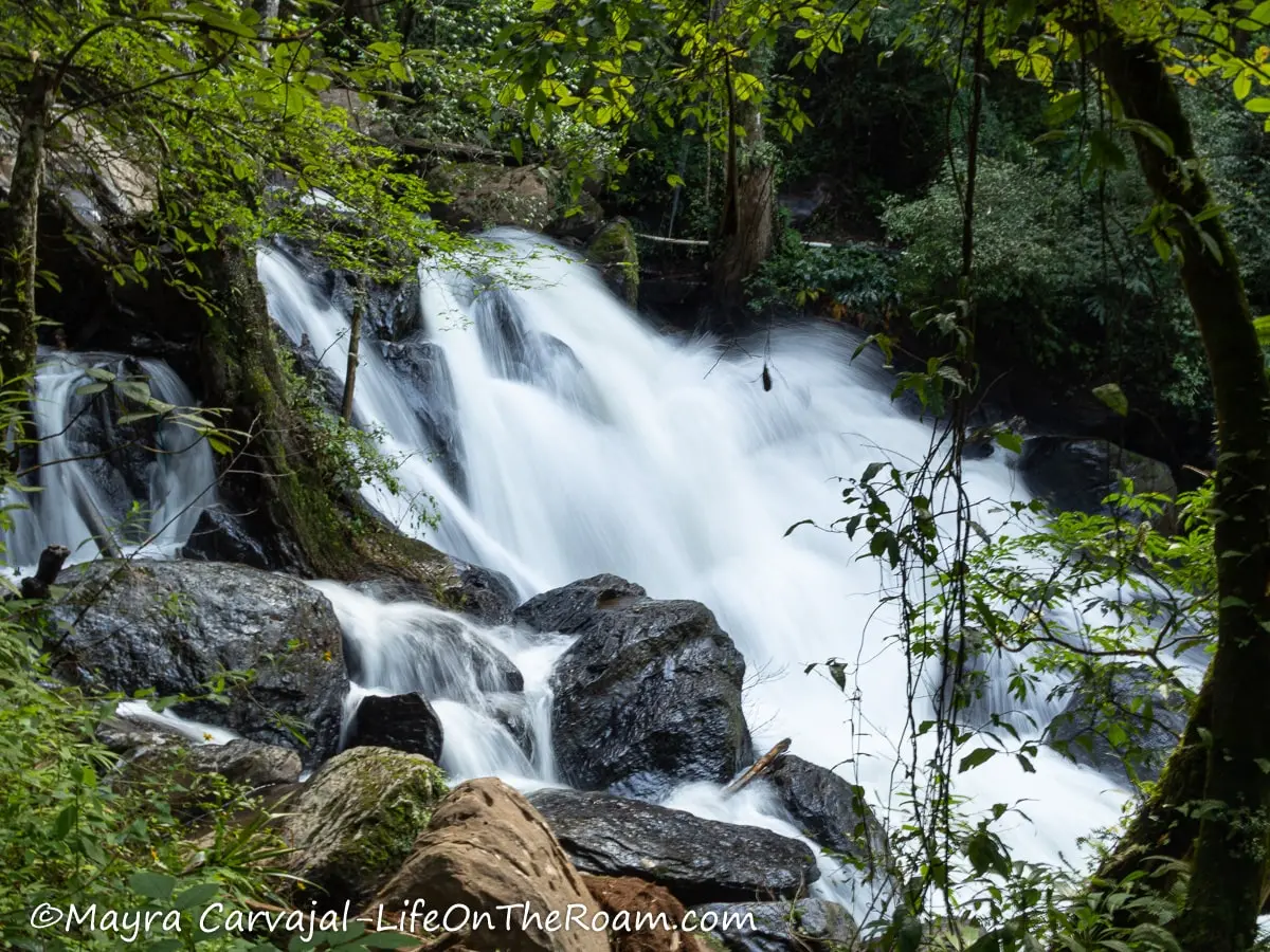 A waterfall over rocks with trees around