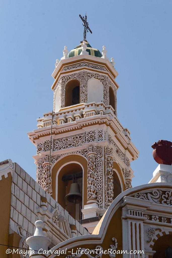 A belfry painted in ochre with mortar decorations in white