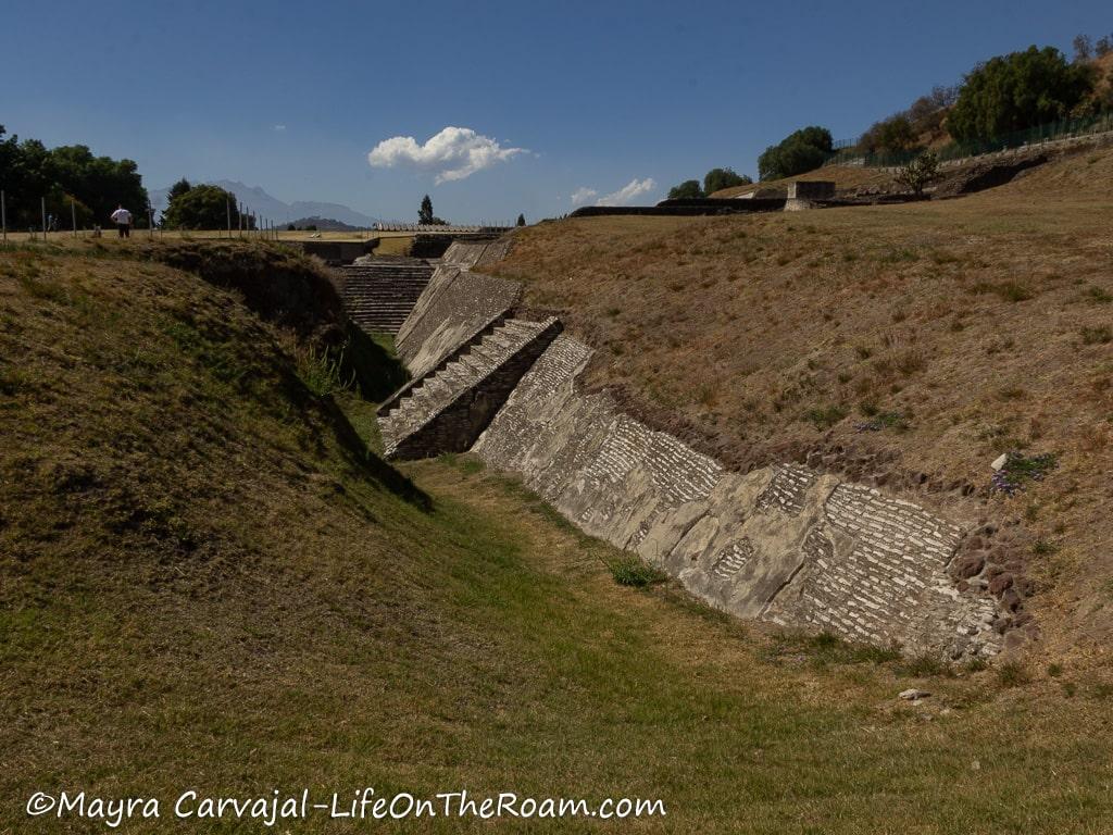 A sloped wall covered with grass and with stairs