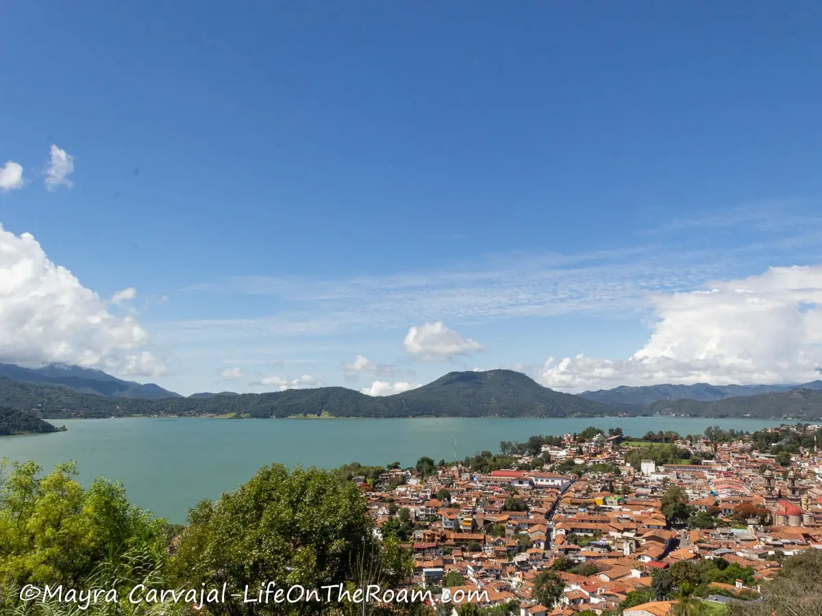 View of a town next to a lake with mountains in the background