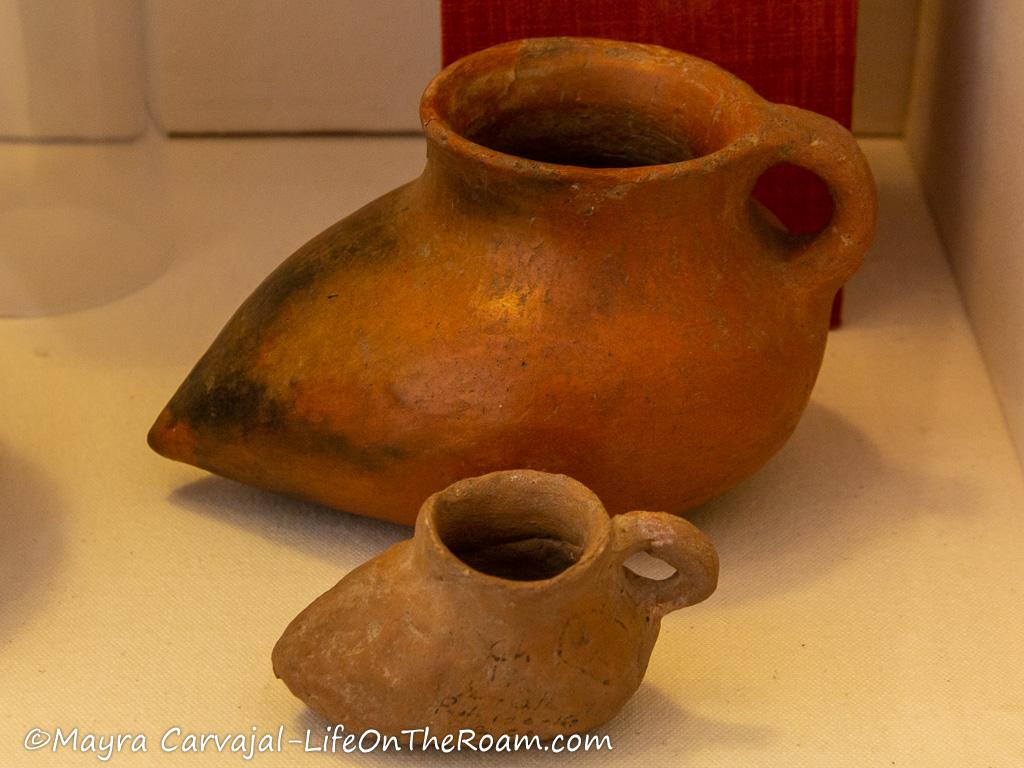 2 elongated pottery vases with an orange tone and no decoration