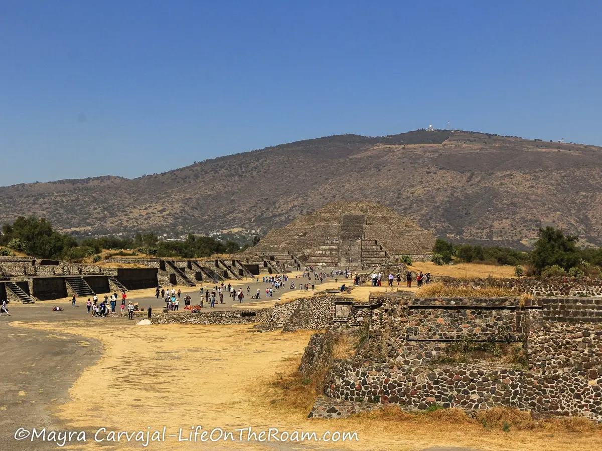 A wide walkway outdoors flanked by pyramids