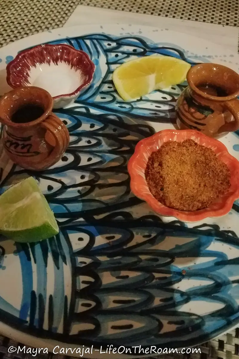 Two small clay jars with lemon quarters and dishes with salt
