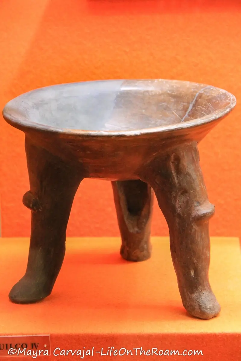 An ancient pottery piece with three legs
