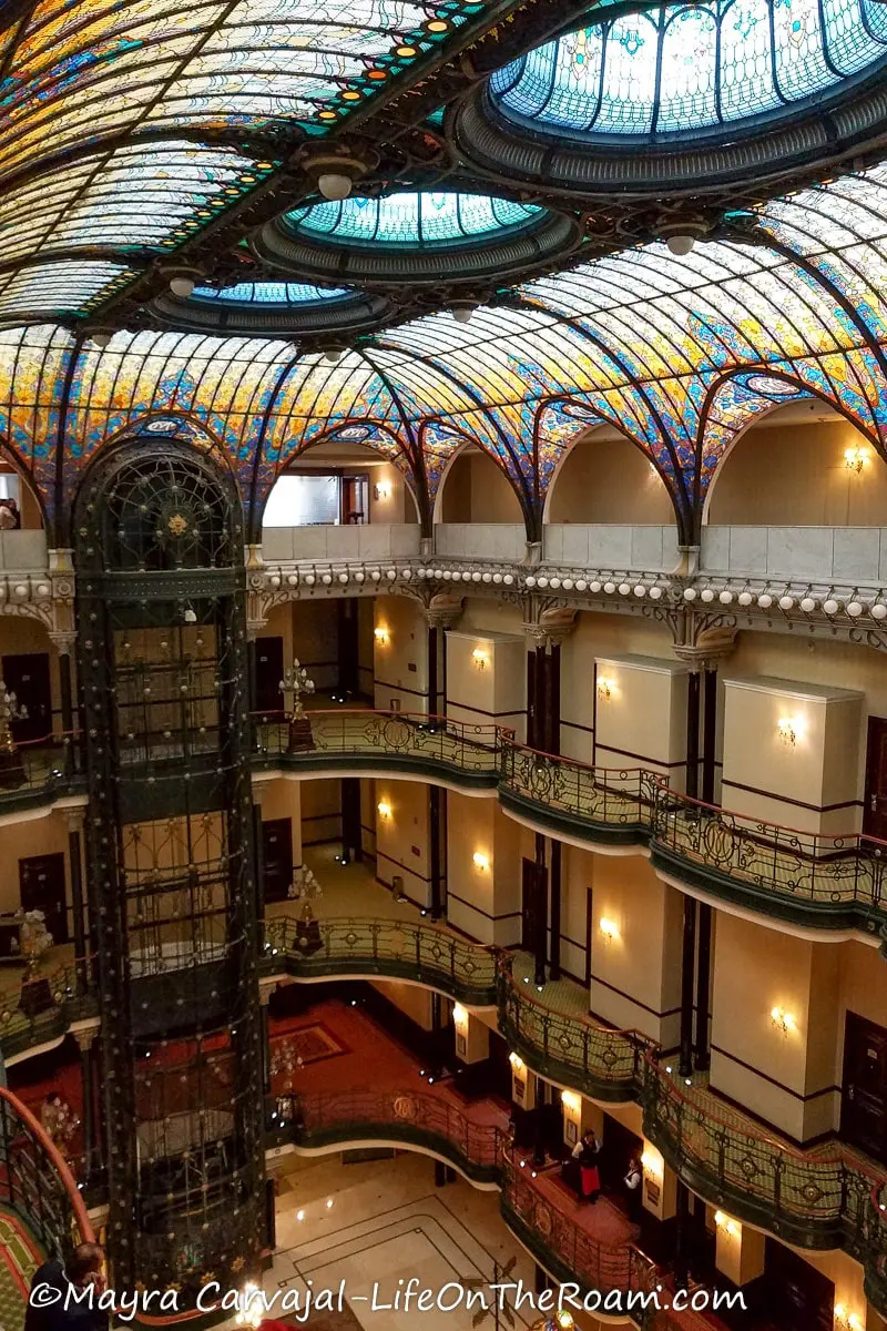 A Tiffany-style ceiling in several colours in a 19th-century style hotel with four storeys