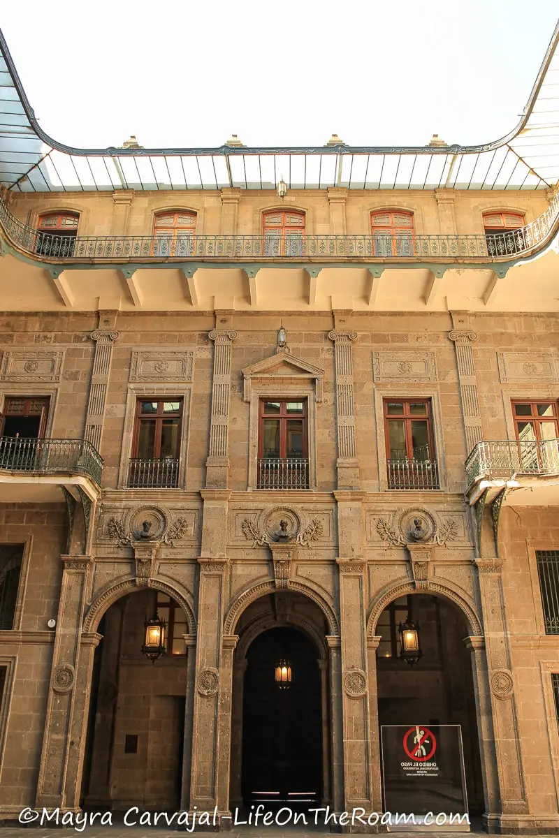 An inner patio in an old stone building with arches and windows