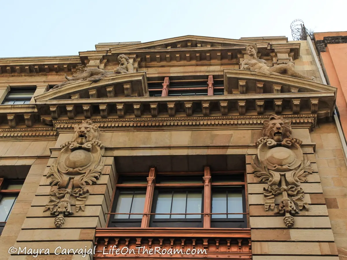 A neo-classical style building with lions and muses in the façade