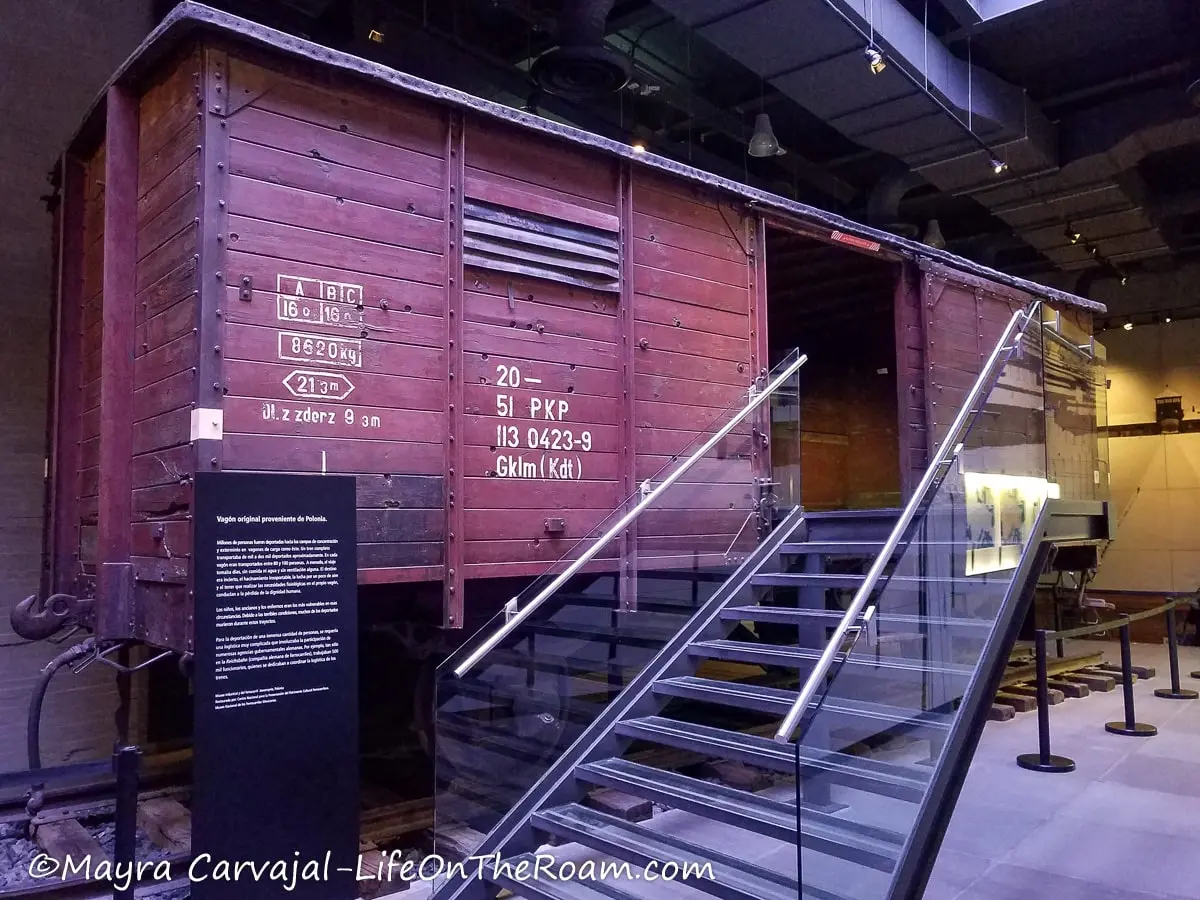 An old wagon train with red wood slats and glass stairs to access it