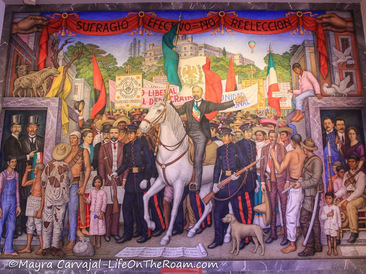 A  mural depicting a historic scene with a figure of authority leaving a castle in a white horse, surrounded by a crowd