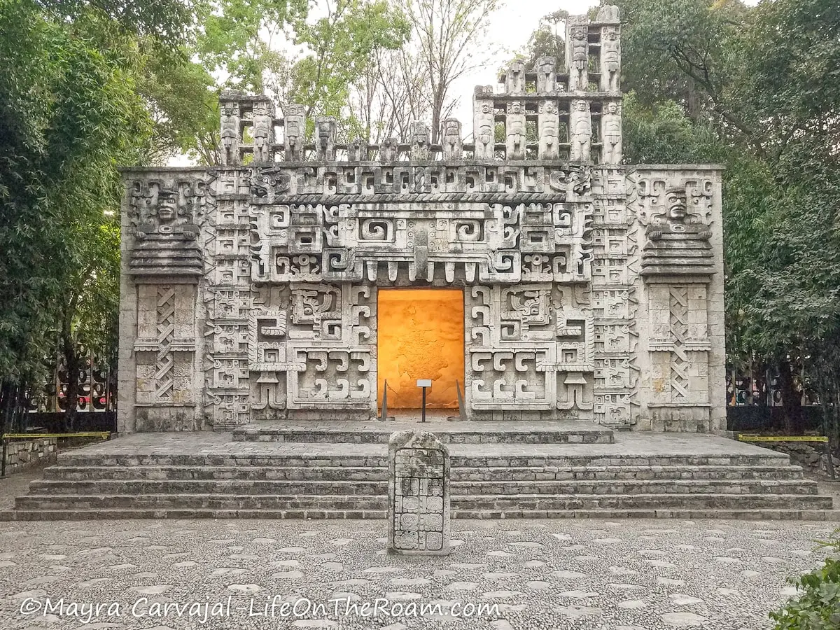 A life-size reproduction of a decorated Mayan temple with vegetation around