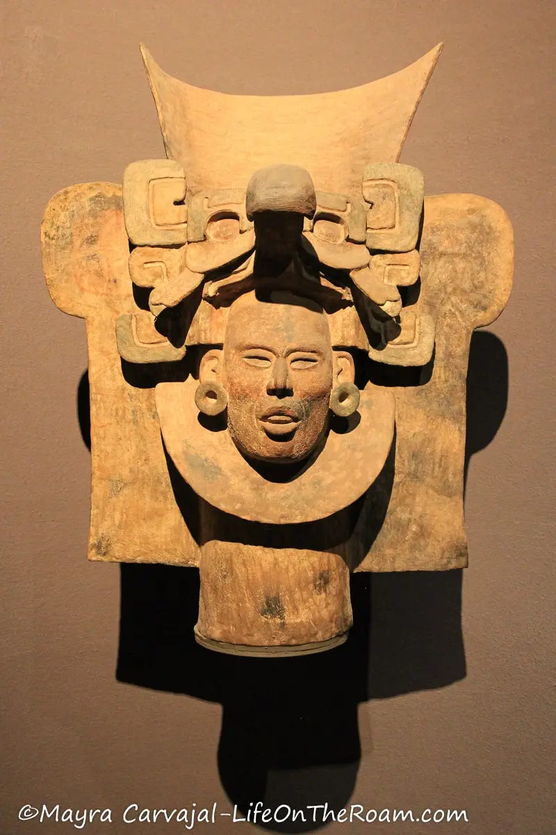 An ancient urn in the shape of the head of a man with a headdress